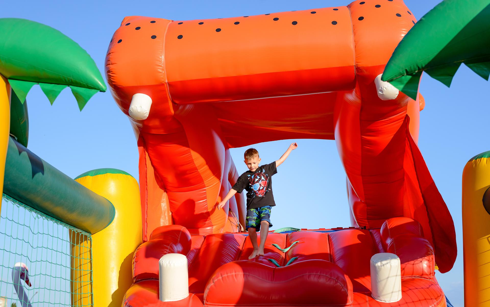 Boy Playing on Giant Red Inflatable Hippopotamus